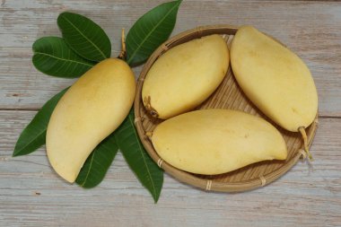 Ahşap arka planda sarı mango