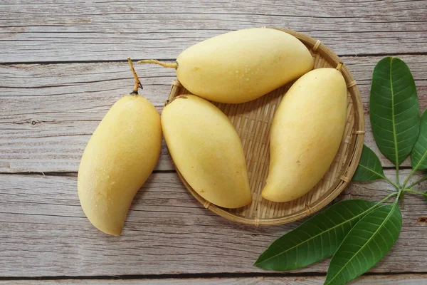 Ahşap arka planda sarı mango