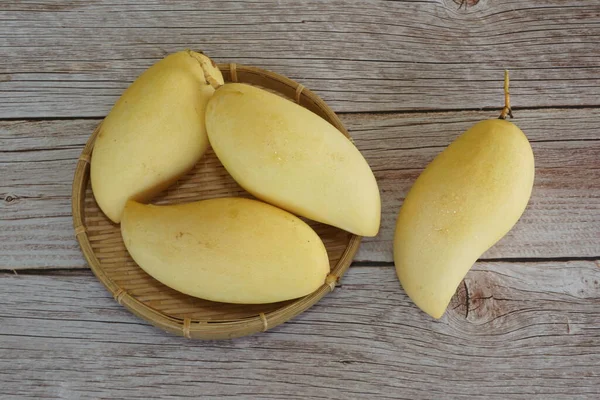 Ahşap arka planda sarı mango