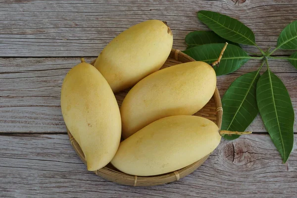 Ahşap arka planda sarı mango