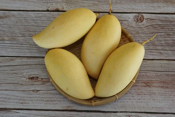 Ahşap arka planda sarı mango