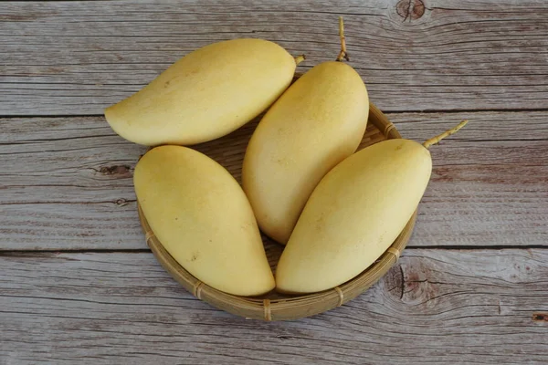 Ahşap arka planda sarı mango