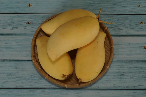 Ahşap arka planda sarı mango