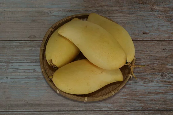 Ahşap arka planda sarı mango