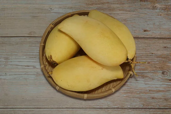 Ahşap arka planda sarı mango