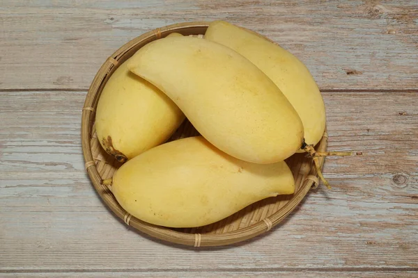 Ahşap arka planda sarı mango