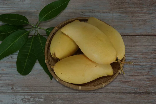 Ahşap arka planda sarı mango
