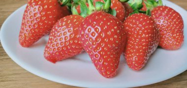 Beyaz tabakta izole edilmiş çilekler.