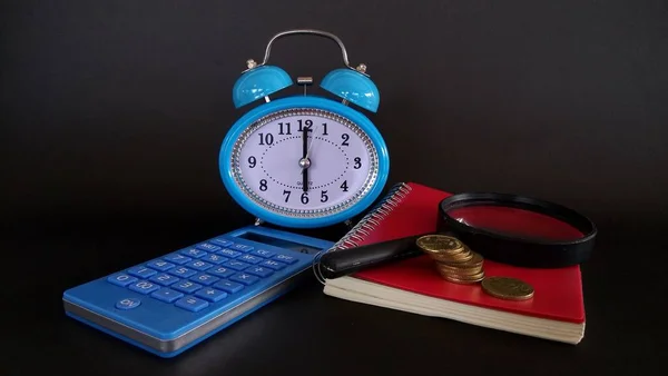blue alarm clock against black background
