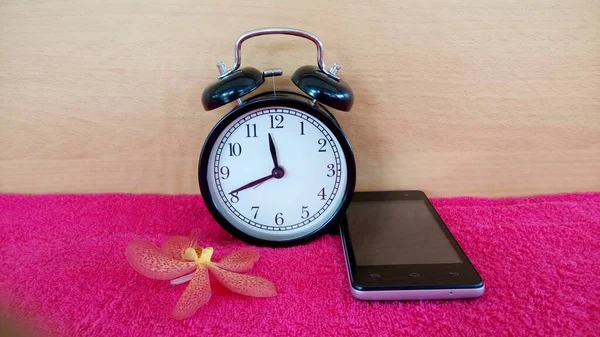 Alarm Clock Orchid Flower Red Towel — Stock Photo, Image