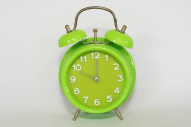 close up of green alarm clock on white background