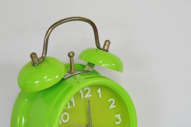 close up of green alarm clock on white background
