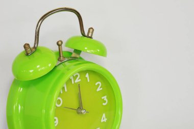 close up of green alarm clock on white background