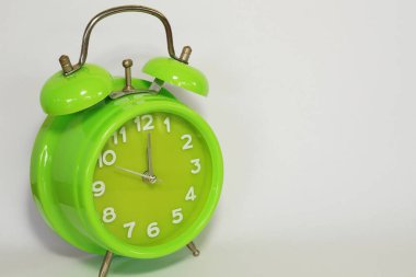 close up of green alarm clock on white background