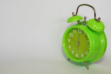 close up of green alarm clock on white background