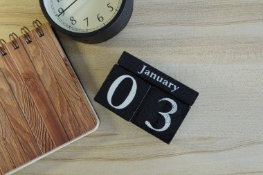 Ahşap zemin üzerinde alarm saati olan küp takvimi