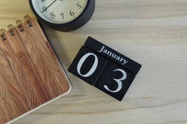 Ahşap zemin üzerinde alarm saati olan küp takvimi