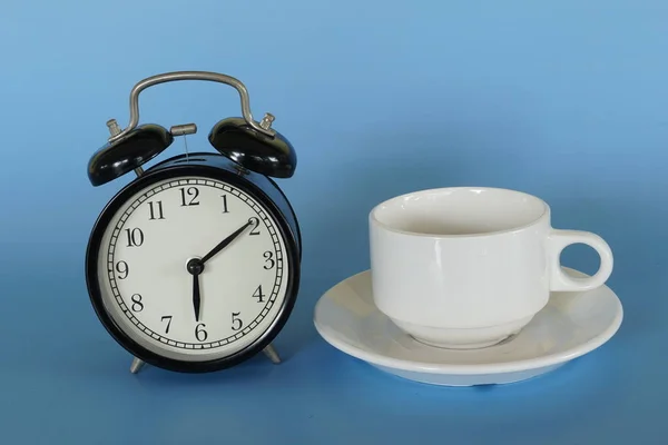 Wecker Und Eine Tasse Kaffee Vor Blauem Hintergrund — Stockfoto