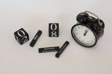 Beyaz arkaplanda takvim küpü olan alarm saati