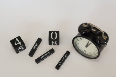 Beyaz arkaplanda takvim küpü olan alarm saati
