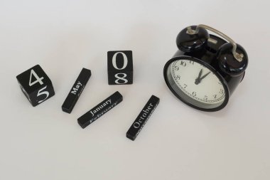 Beyaz arkaplanda takvim küpü olan alarm saati