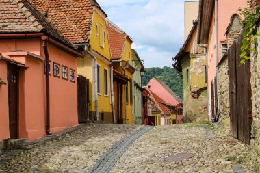 Taş, Romanya 'nın Sighisoara kentinde renkli evleri olan eski sokakları asfaltladı. Şehrin tarihi merkezi UNESCO Dünya Mirasları Alanıdır..