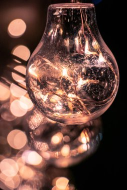 Arkasında bokeh etkisi olan bir festival dekorasyon ampulünün yakın çekimi.