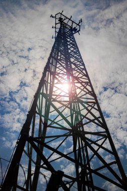 Çok ama çok uzun bir telekomünikasyon anteni. Dipten yukarı açılı ve yerden belli bir perspektifi var. Güneşli bir gün ve mavi gökyüzü arkaplanı ve parlak lensleri var.