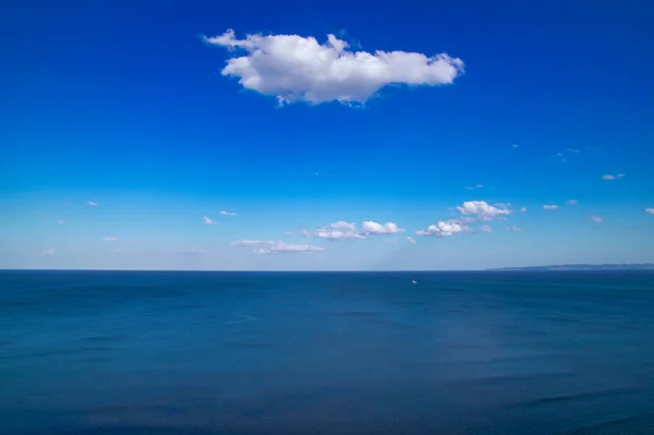 Hermoso paisaje marino natural en un día soleado. Mundo de belleza, cielo azul con nubes blancas. Fondo azul profundo, fondo de pantalla — Foto de Stock