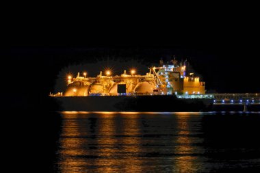 LNG tanker moored in the factory area at night. clipart