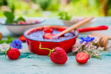 Homemade jam with fresh strawberries.