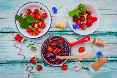 Homemade jam with fresh strawberries.