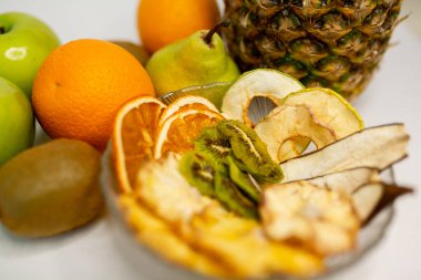 Meyve, marşmelov ve meyve cipsi masada.