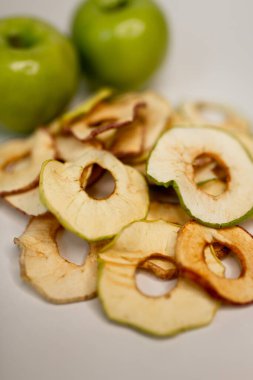 Meyve, marşmelov ve meyve cipsi masada.