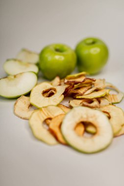 Meyve, marşmelov ve meyve cipsi masada.