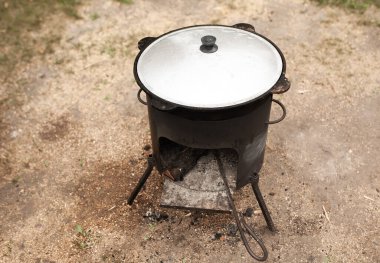 Kazan sıcak bir günde bir açıklıkta duruyor. İçinde sigara var.