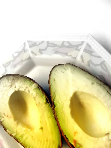 Avocado Půlky Porcelánovém Talíři — Stock fotografie