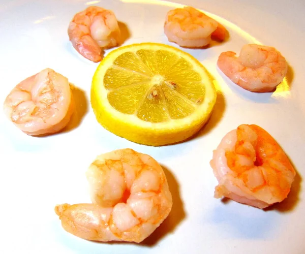 柠檬片 由瓷盘中新鲜的虾仁环绕 — 图库照片