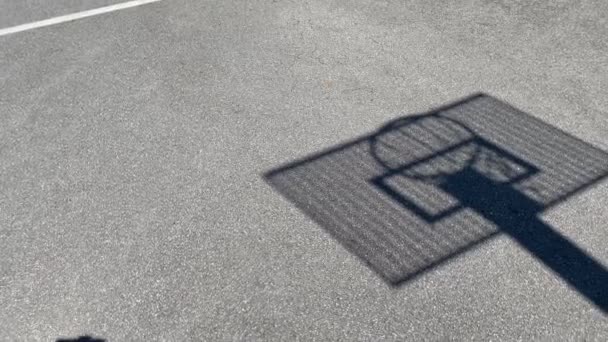 学校のサイト上の金属板と影、シルエットバスケットボールのフープ — ストック動画