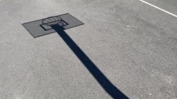 Σκιά, σιλουέτα Μπάσκετ στεφάνι με το μεταλλικό πίνακα σε μια σχολική ιστοσελίδα — Αρχείο Βίντεο