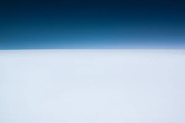 Limpar o céu minimalista e escuro campo de neve — Fotografia de Stock