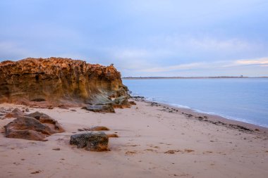 Yumuşak sabah ışığı, Port Hedland kıyı şeridini aydınlatarak gelgit düzlüklerini, kızıl toprağı ve sakin mavi suları ortaya çıkarır. Huzurlu sahne, Batı Avustralya Pilbara bölgesinin doğal güzelliğini ve kendine özgü kıyı manzarasını yansıtıyor..