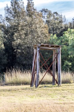 Kırsal, yıllanmış kereste su deposu yıpranma ve yıpranma gösteriyor. Kaba ahşap, çatlaklar ve doğal dokular, işlevsel, yaşlanmış kırsal yapıların cazibesini vurgulayarak, elementlere yıllarca maruz kalmanın etkilerini yansıtıyor..