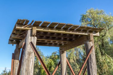 Kırsal, yıllanmış kereste su deposu yıpranma ve yıpranma gösteriyor. Kaba ahşap, çatlaklar ve doğal dokular, işlevsel, yaşlanmış kırsal yapıların cazibesini vurgulayarak, elementlere yıllarca maruz kalmanın etkilerini yansıtıyor..