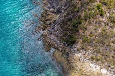 Queenslands WhitSunday Sahili 'ndeki Hydeaway Körfezi' nin nefes kesici bir görüntüsü. Turkuaz sular, beyaz kumlu plajlar ve bereketli tropikal manzaralar Avustralya Mercan Denizi bölgesinin doğal güzelliklerini gözler önüne seren sakin bir sahil cenneti yaratıyor..