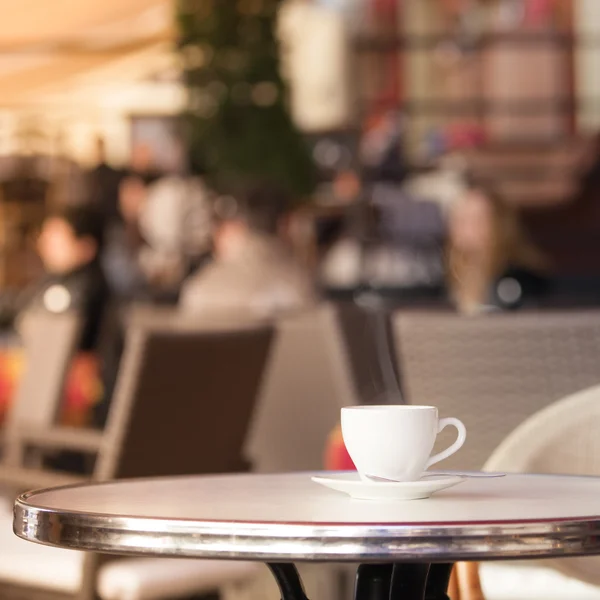 Біла чашка кави за літнім столом кафе — стокове фото
