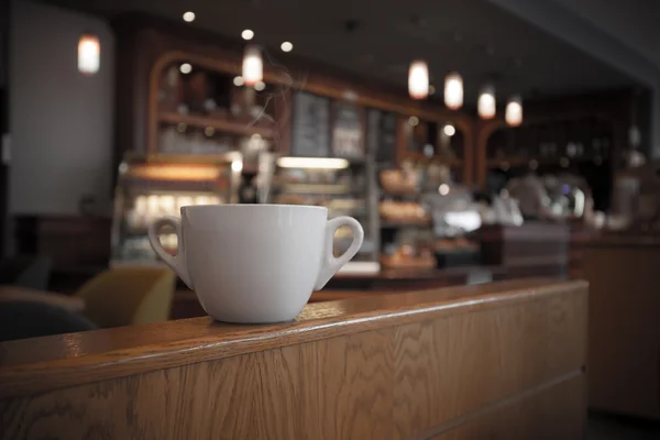 Witte kop koffie in het café-interieur — Stockfoto