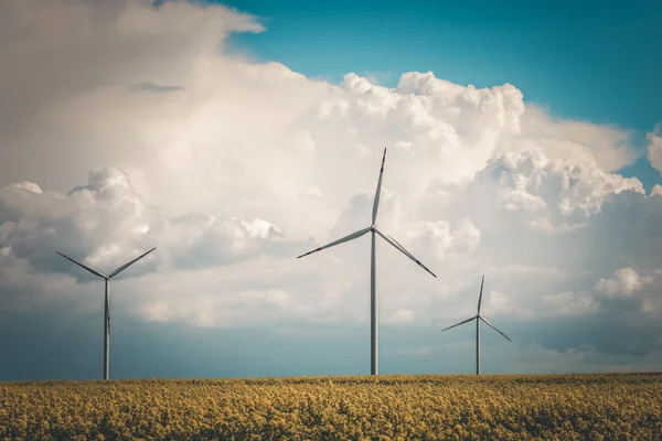 Винтажное фото ветряной электростанции на желтом поле — стоковое фото