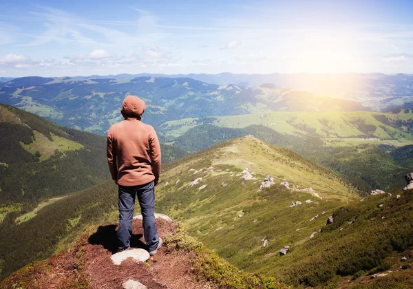 Hombre de pie en la cima de la montaña — Foto de Stock