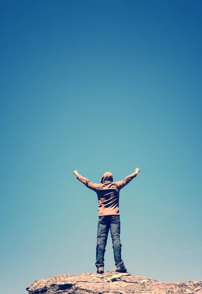 Homme debout sur le sommet de la montagne au-dessus du ciel bleu — Photo